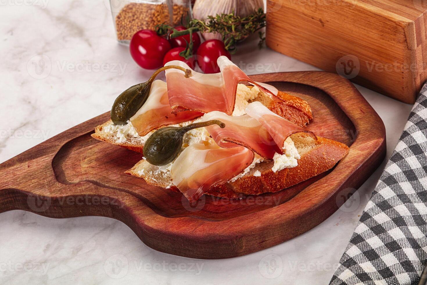 Bruschetta with jamon and caper berries photo