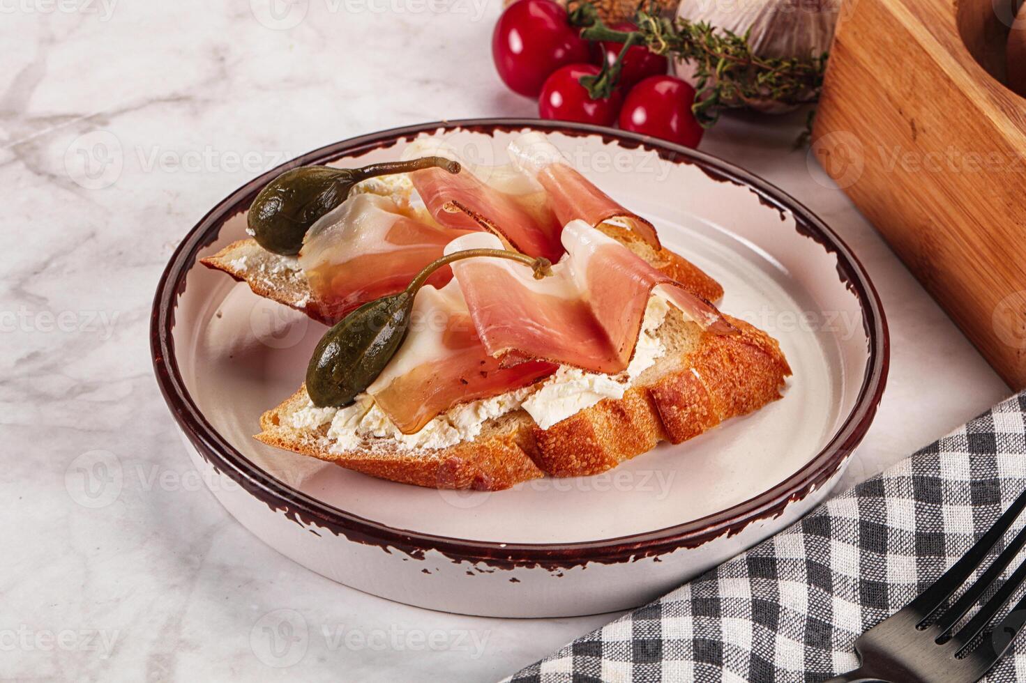 Bruschetta with jamon and caper berries photo