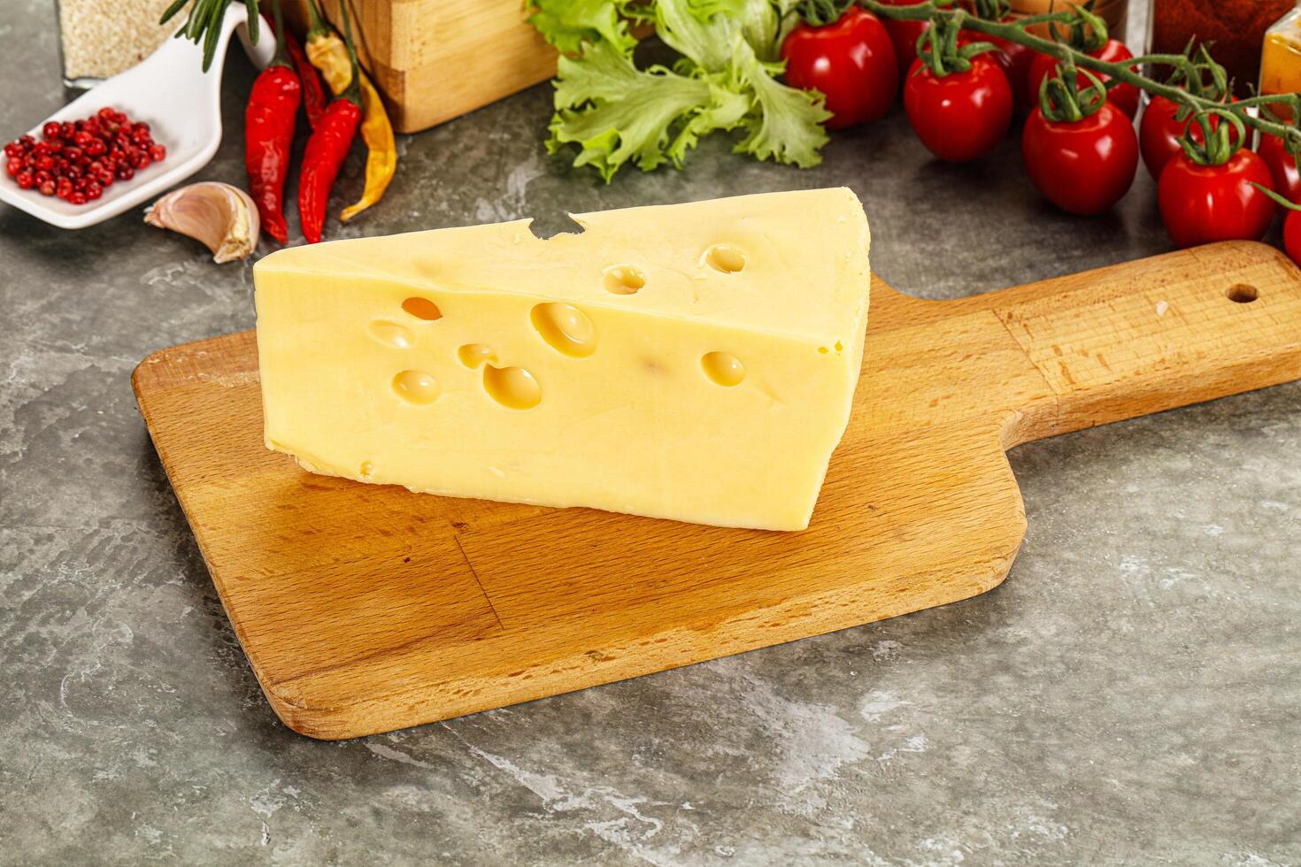 Swiss Maasdam cheese triangle over board photo