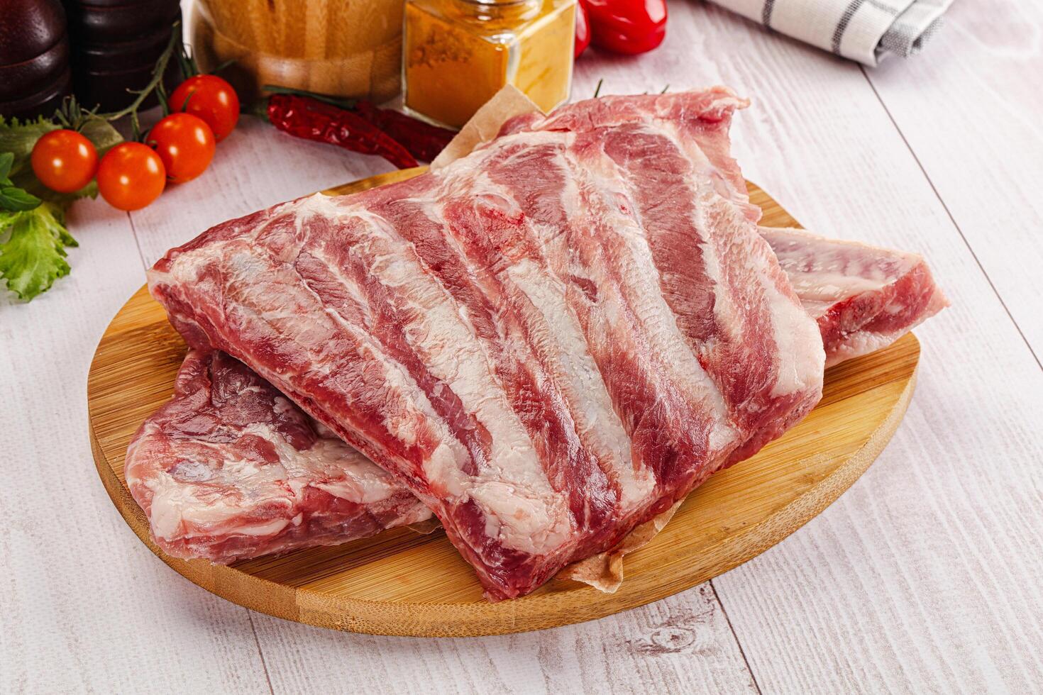 Raw pork ribs over board photo