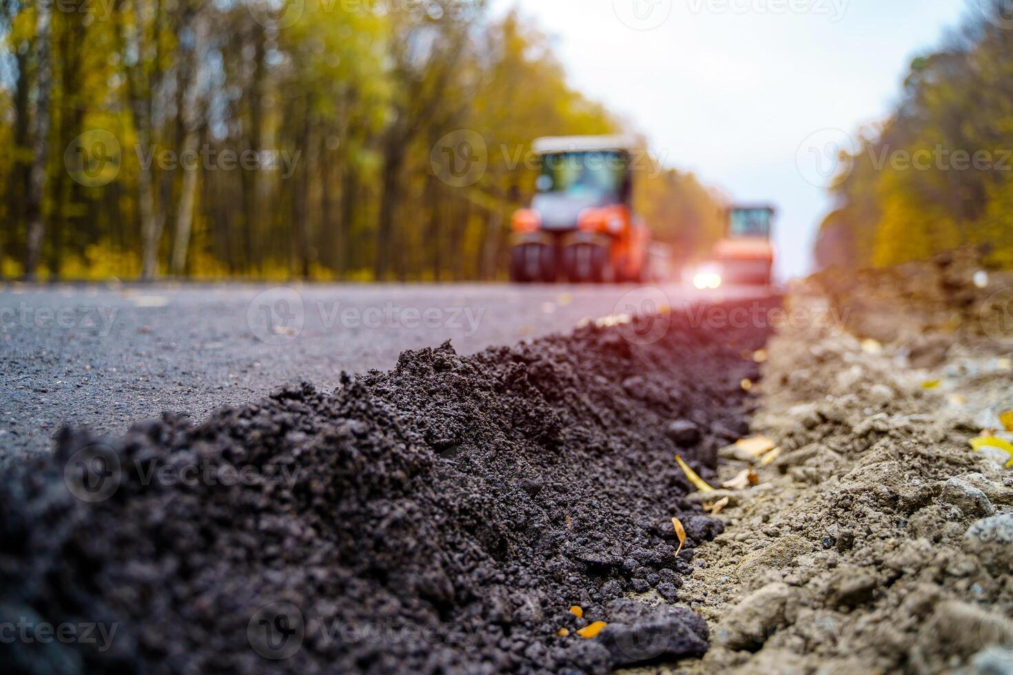 Workers operating asphalt paver machine during road construction. Close view on the road roller working on the new road construction site photo