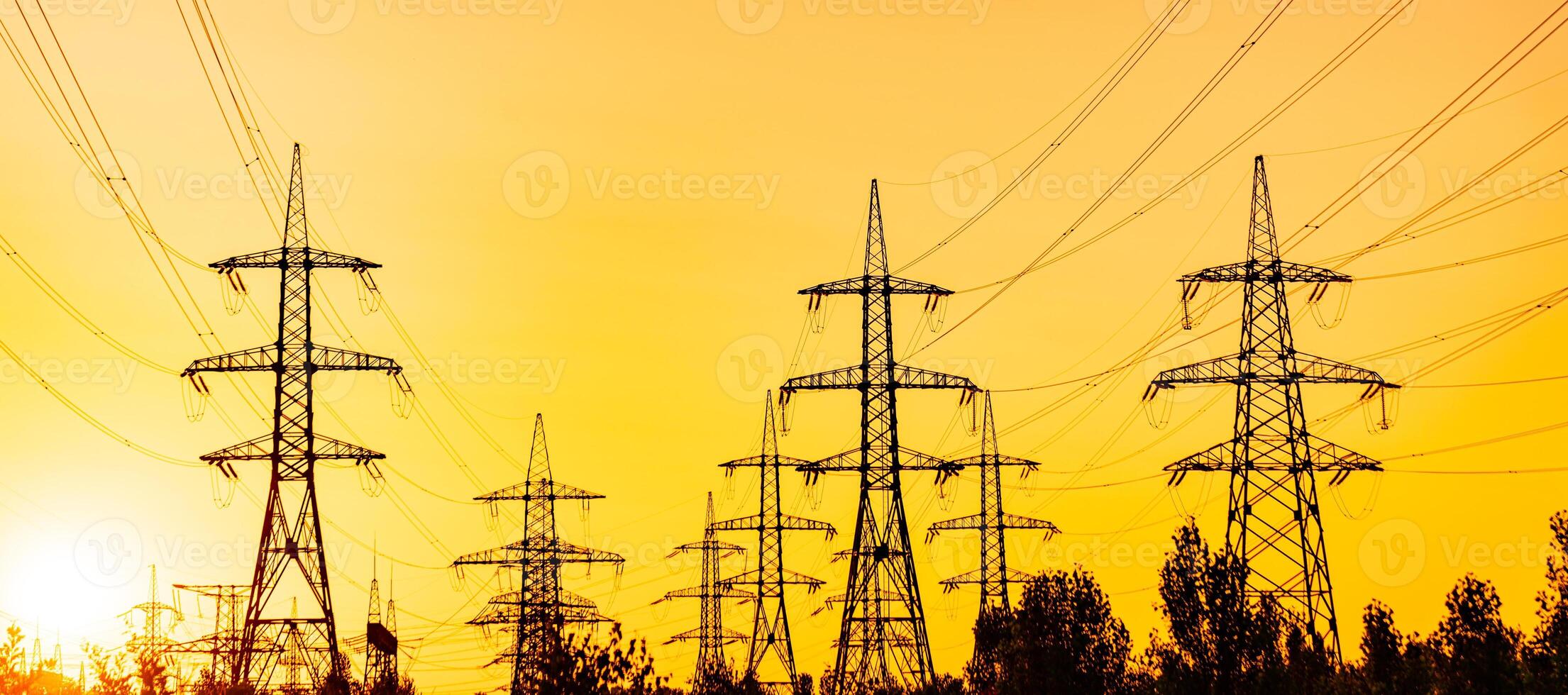 High power electricity poles. View of high voltage electrical transmission tower. The rising sun above the power line photo