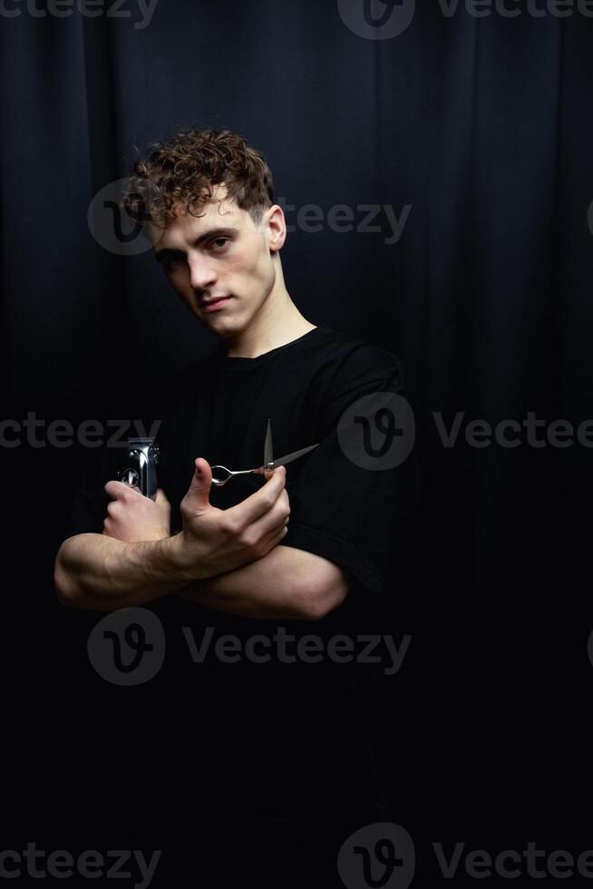 Handsome men. Barber holds in his hands a clipper and a Scissors photo