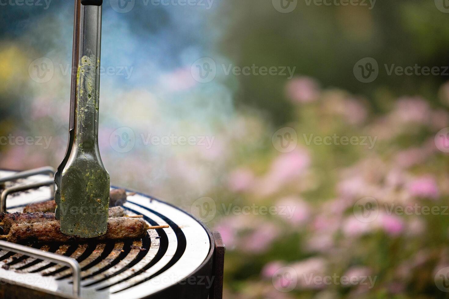 juicy kebabs on a barbecue grill with smoke. Relaxing and delicious barbecue in the backyard. photo