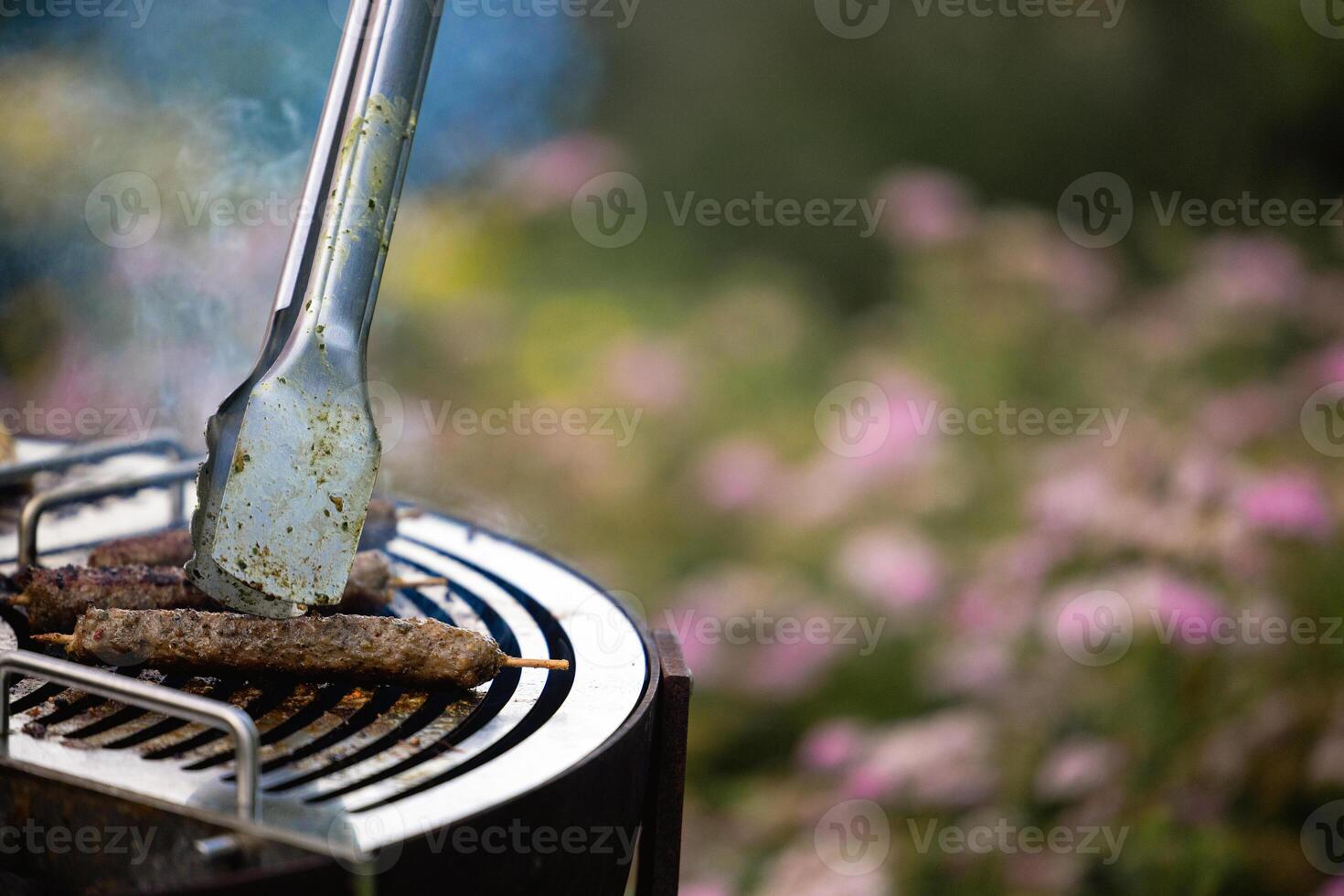 juicy kebabs on a barbecue grill with smoke. Relaxing and delicious barbecue in the backyard. photo