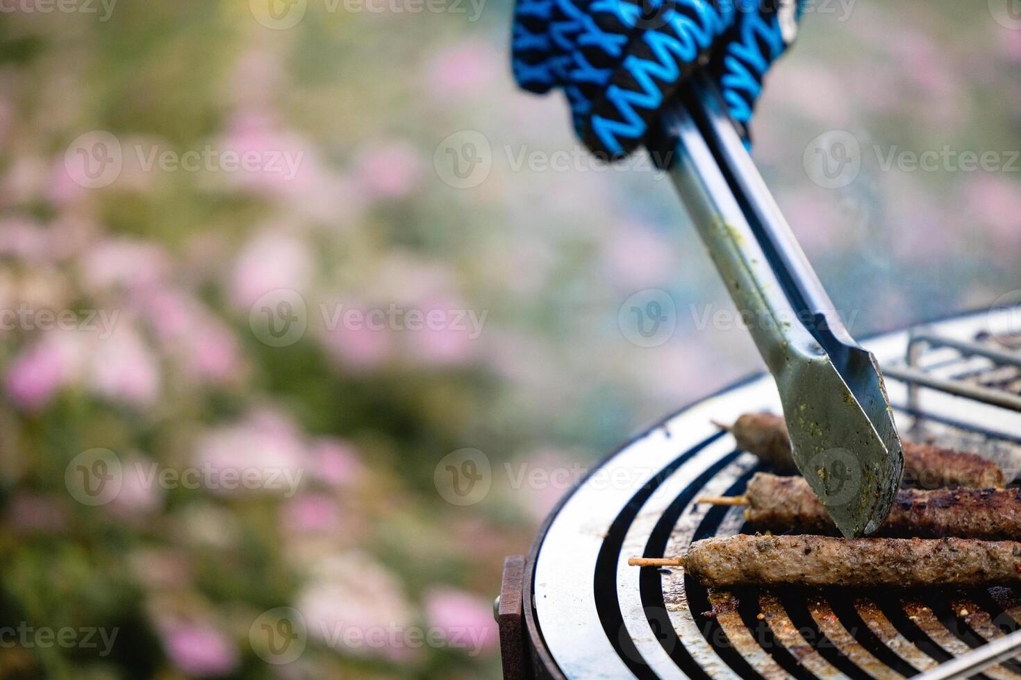 juicy kebabs on a barbecue grill with smoke. Relaxing and delicious barbecue in the backyard. photo