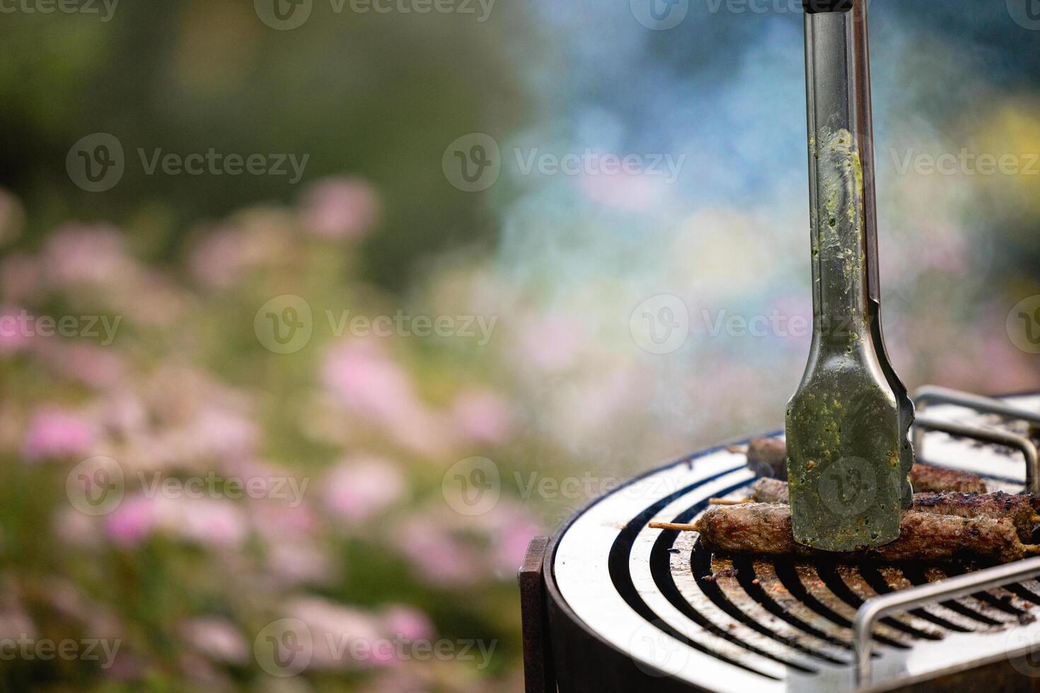 juicy kebabs on a barbecue grill with smoke. Relaxing and delicious barbecue in the backyard. photo