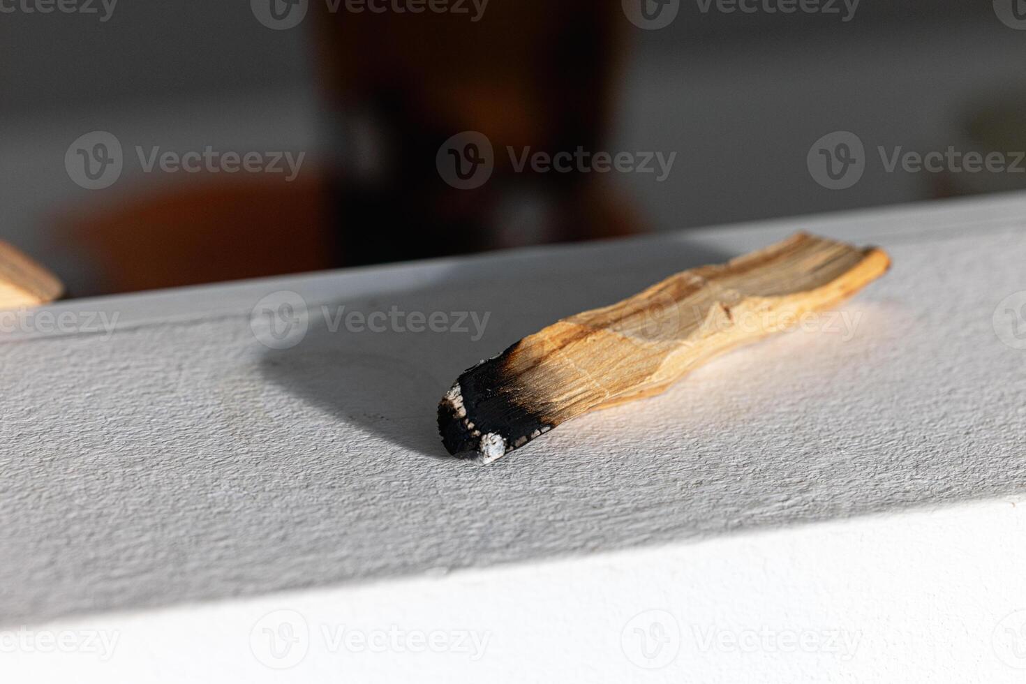 A smoking palo santo wood stick cleansing the energy of the home. Feng Shui for the house. photo