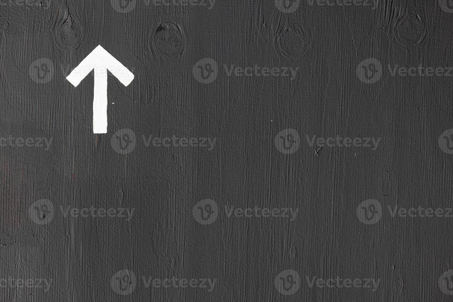 A white arrow on a gray wall with space for text photo