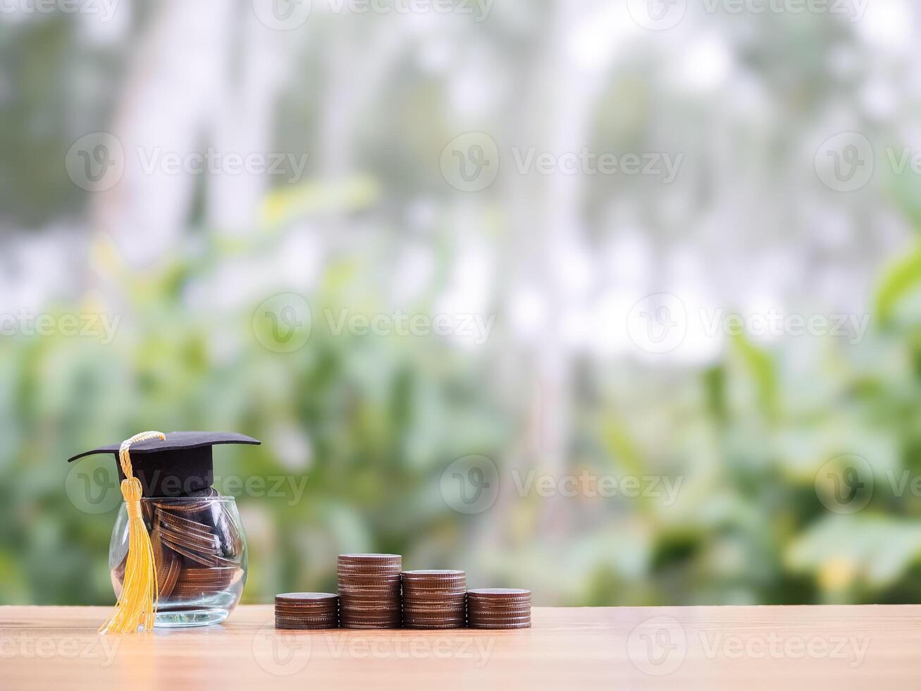 Glass bottle with graduation hat and stack of coins. The concept of saving money for education, student loan, scholarship, tuition fees in the future photo