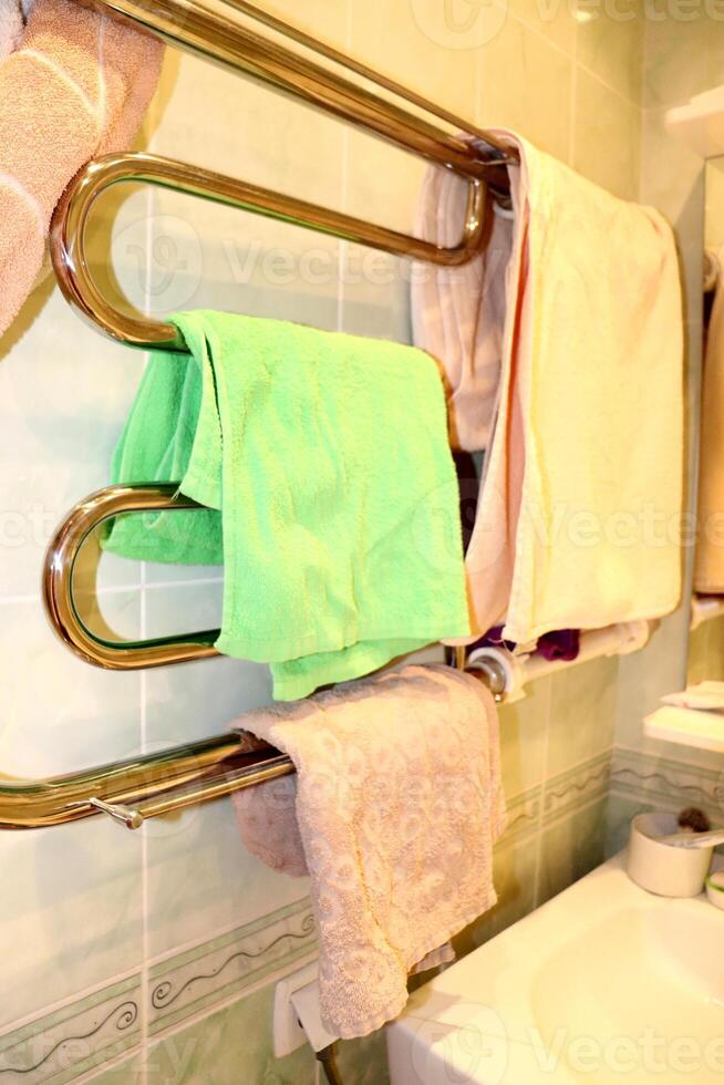 Crumpled cotton towels for face, part of sink and mirror photo