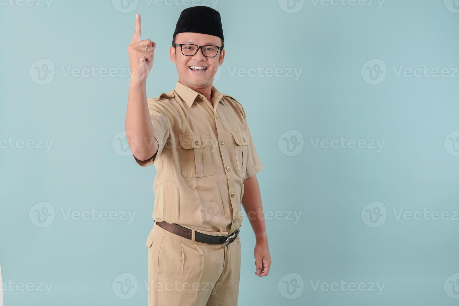 Excited Indonesian government worker man wearing khaki uniform giving number one by hand gesture. photo