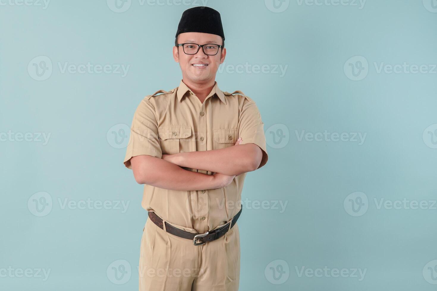 Confident government worker man wearing khaki uniform smiling and standing with his arms crossed. photo