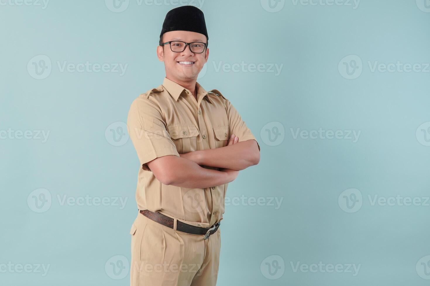 Confident government worker man wearing khaki uniform smiling and standing with his arms crossed. photo