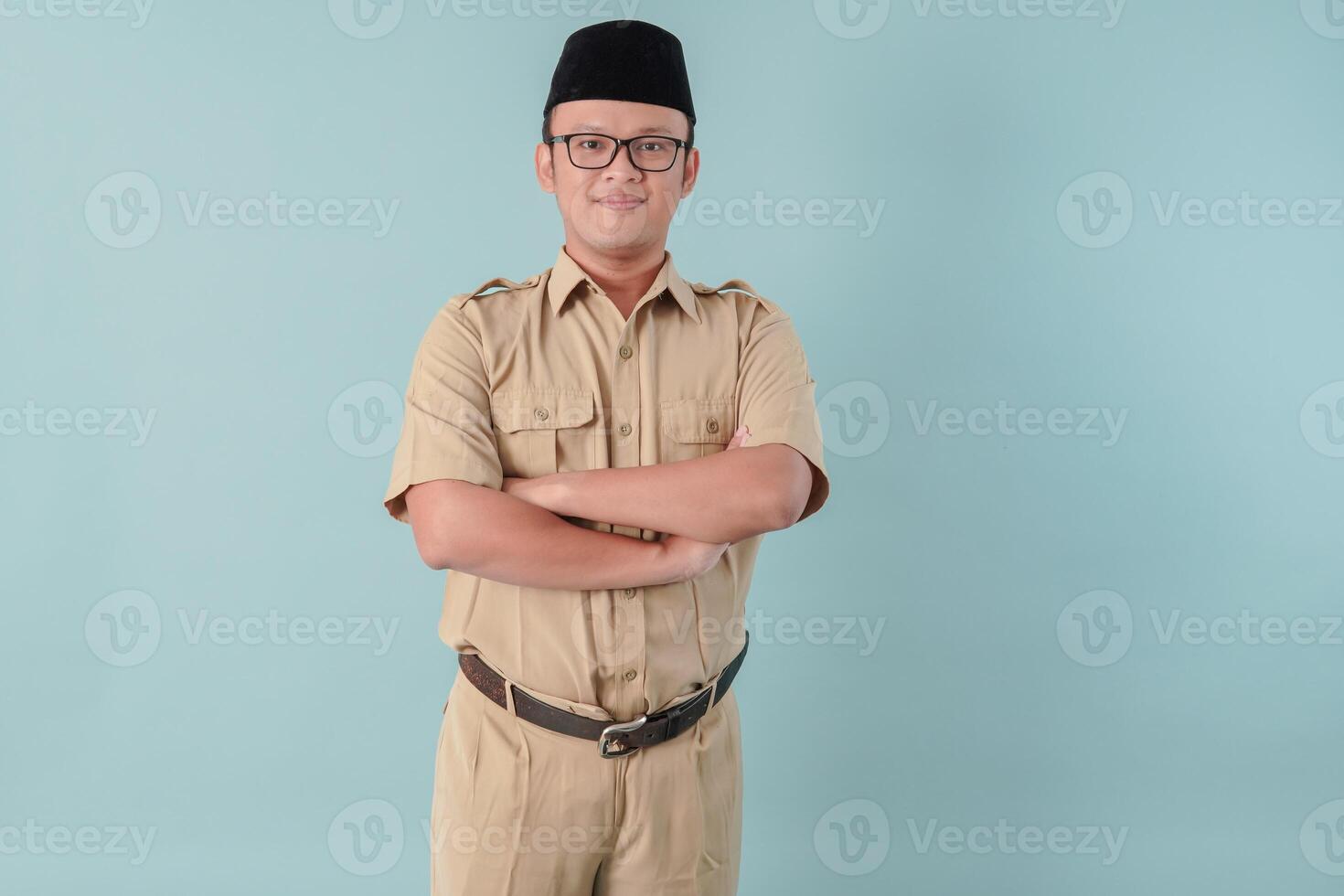 Confident government worker man wearing khaki uniform smiling and standing with his arms crossed. photo