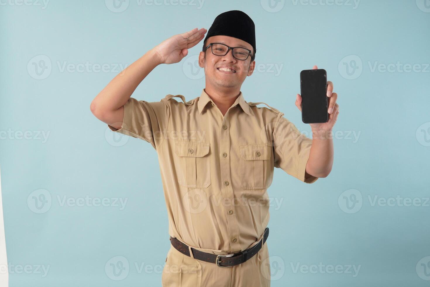 Confident Indonesian government worker doing salute pose while presenting copy space on his phone. photo