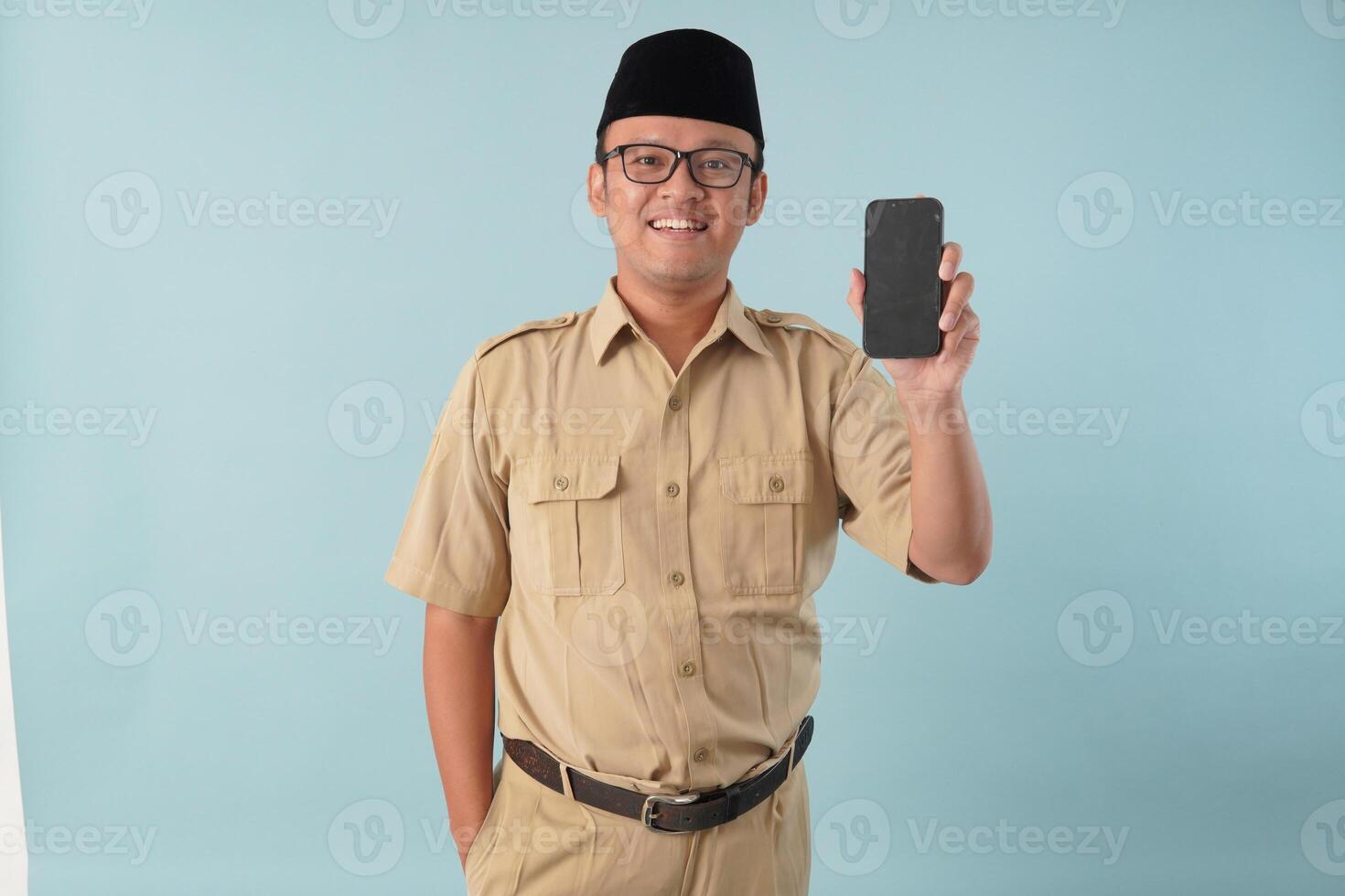 Smiling government worker man wearing khaki uniform presenting copy space on smartphone. photo