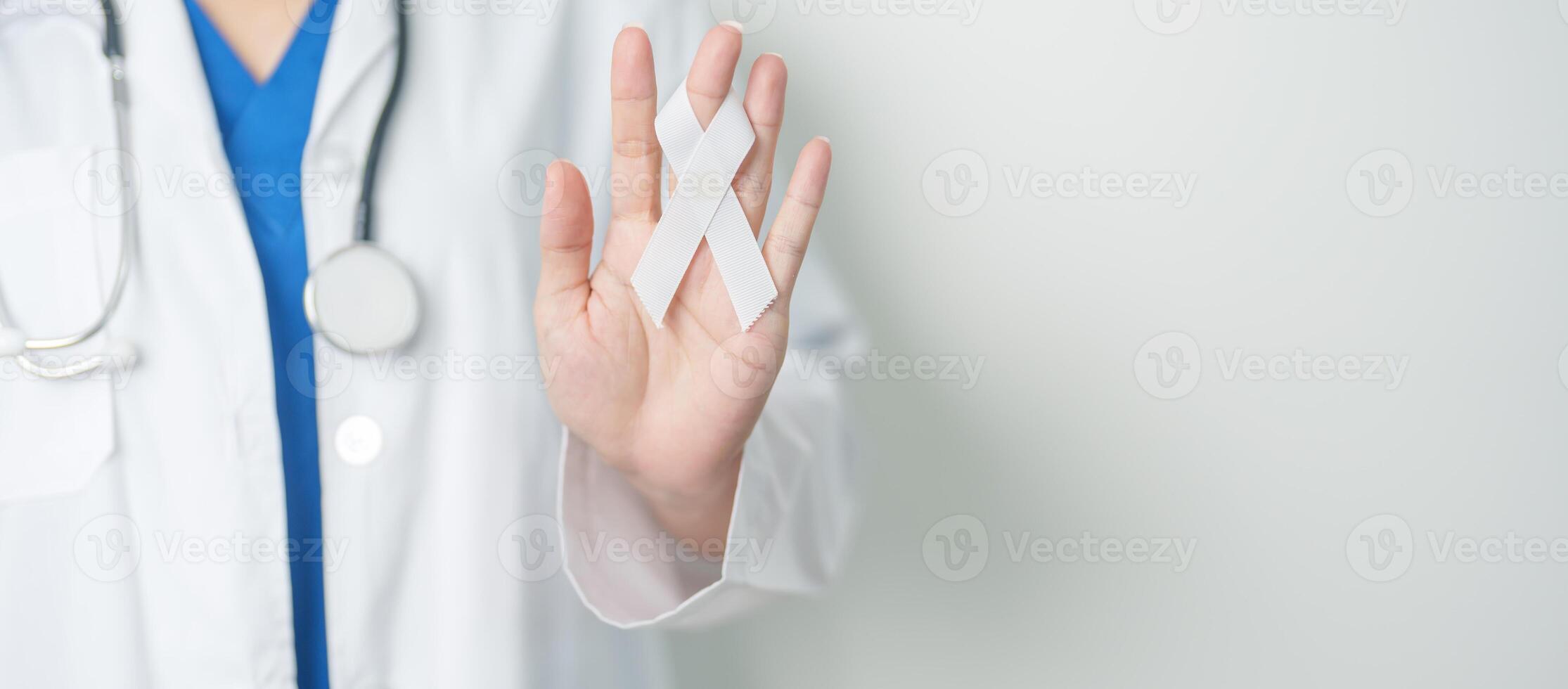 November Lung Cancer Awareness month and Stop Violence Against Women. Doctor with White ribbon in hospital. Healthcare and World Cancer day concept photo