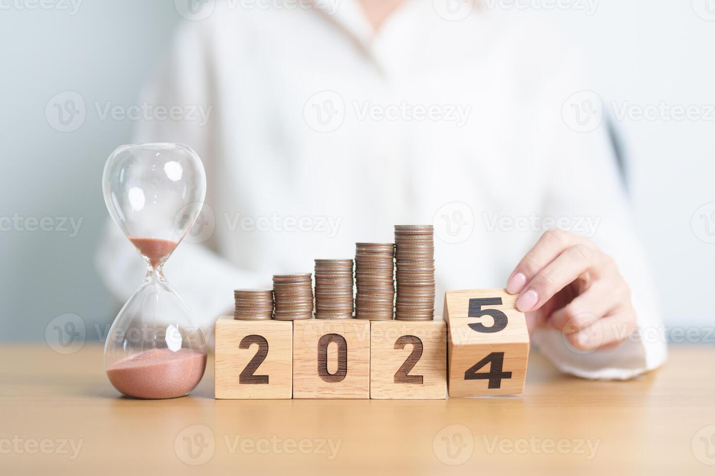2024 end year to Happy New Year 2025 with hourglass and coins stack arrangement. Money Saving for Future Plan, Retirement fund, Pension, Investment, Wealth Business, Financial and countdown concepts photo