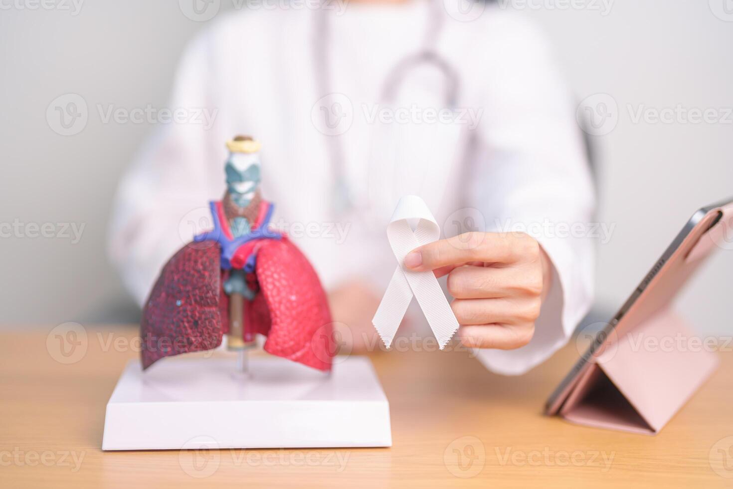 November Lung Cancer Awareness month. Doctor with Smoker Lung anatomy model and White ribbon in hospital. Healthcare and World Cancer day concept photo