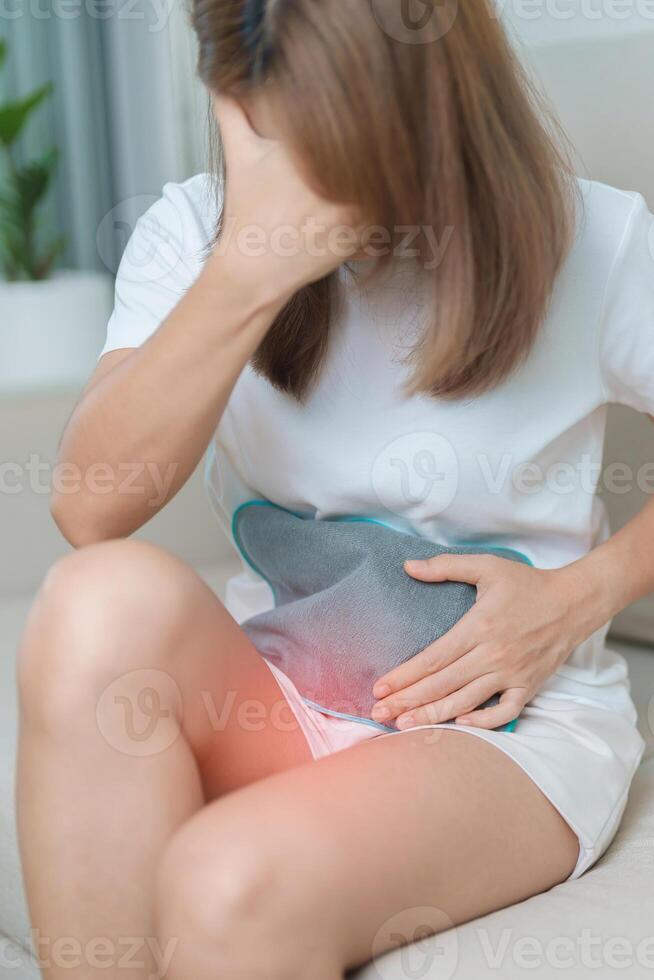 Menstruation period cycle of monthly and Stomachache concepts. woman having abdomen pain and menstrual ache with hot water bottle, illness female suffer from premenstrual ache and body Health problem photo