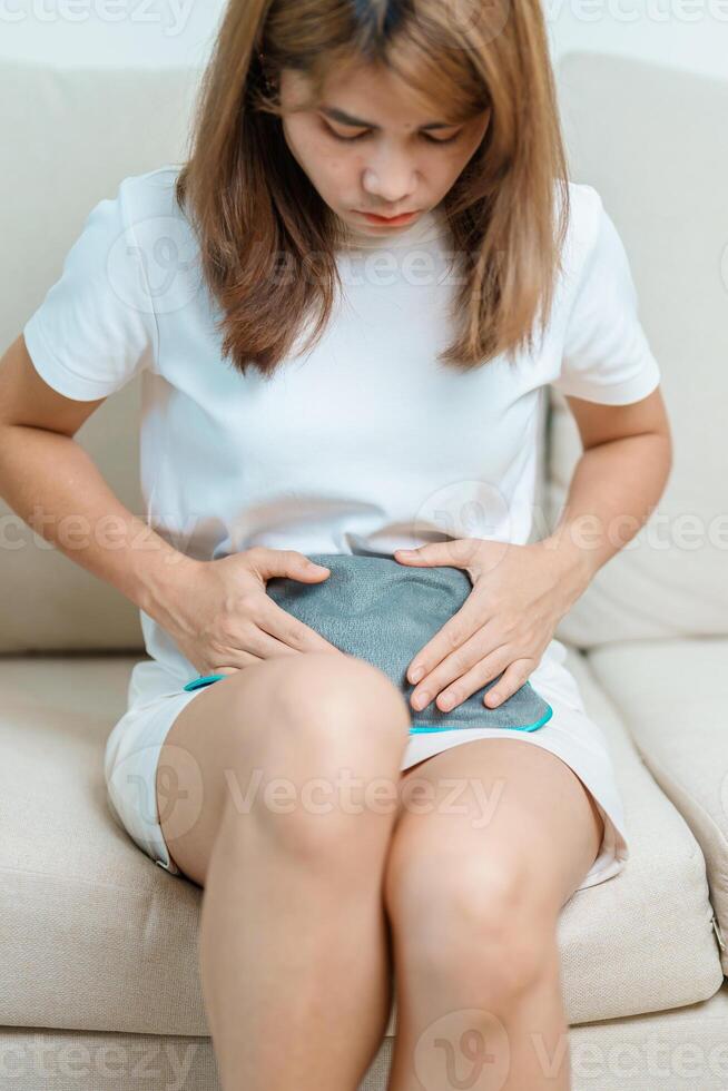 Menstruation period cycle of monthly and Stomachache concepts. woman having abdomen pain and menstrual ache with hot water bottle, illness female suffer from premenstrual ache and body Health problem photo