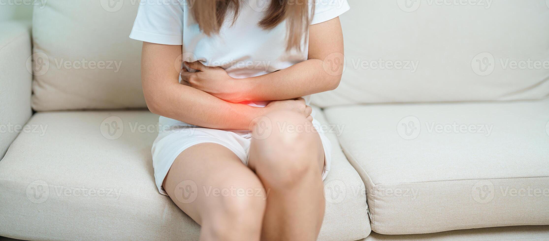 woman having abdomen ache due to Stomach pain, digestion with constipation or Diarrhea from food poisoning, female problem and Endometriosis, Hysterectomy, Stomachache and Menstrual on sofa at home photo