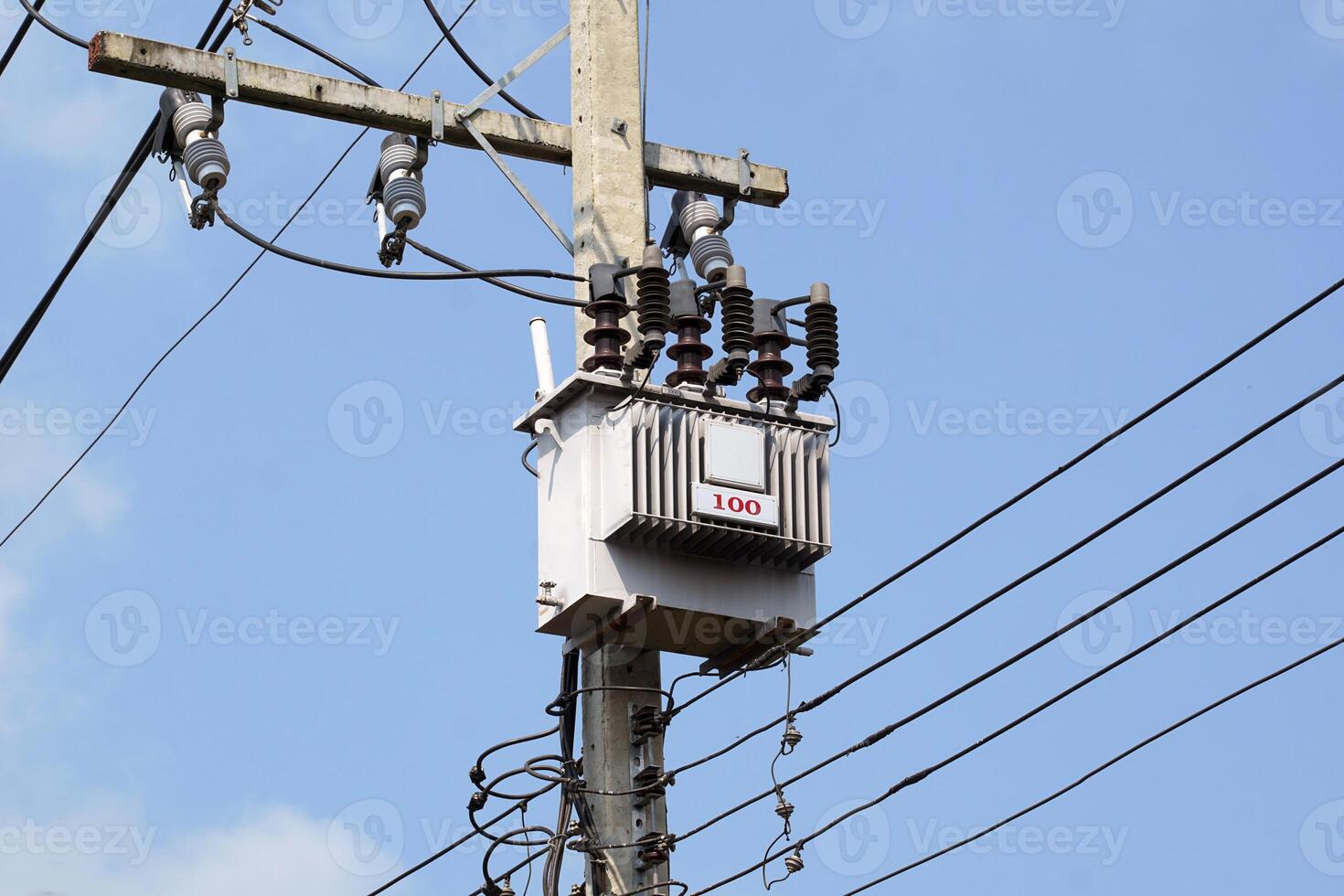 Power transformer installed on electric pole on daytime sky background. Soft and selective focus. photo