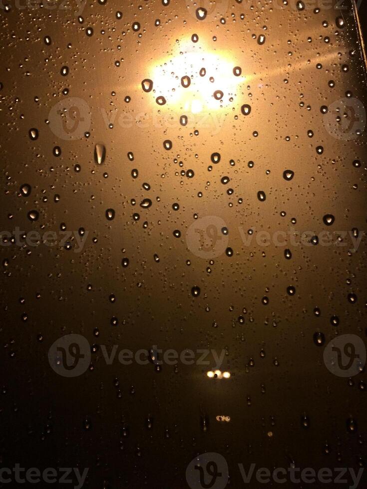 Rain Drops on Glass Window at Night by Streetlight photo