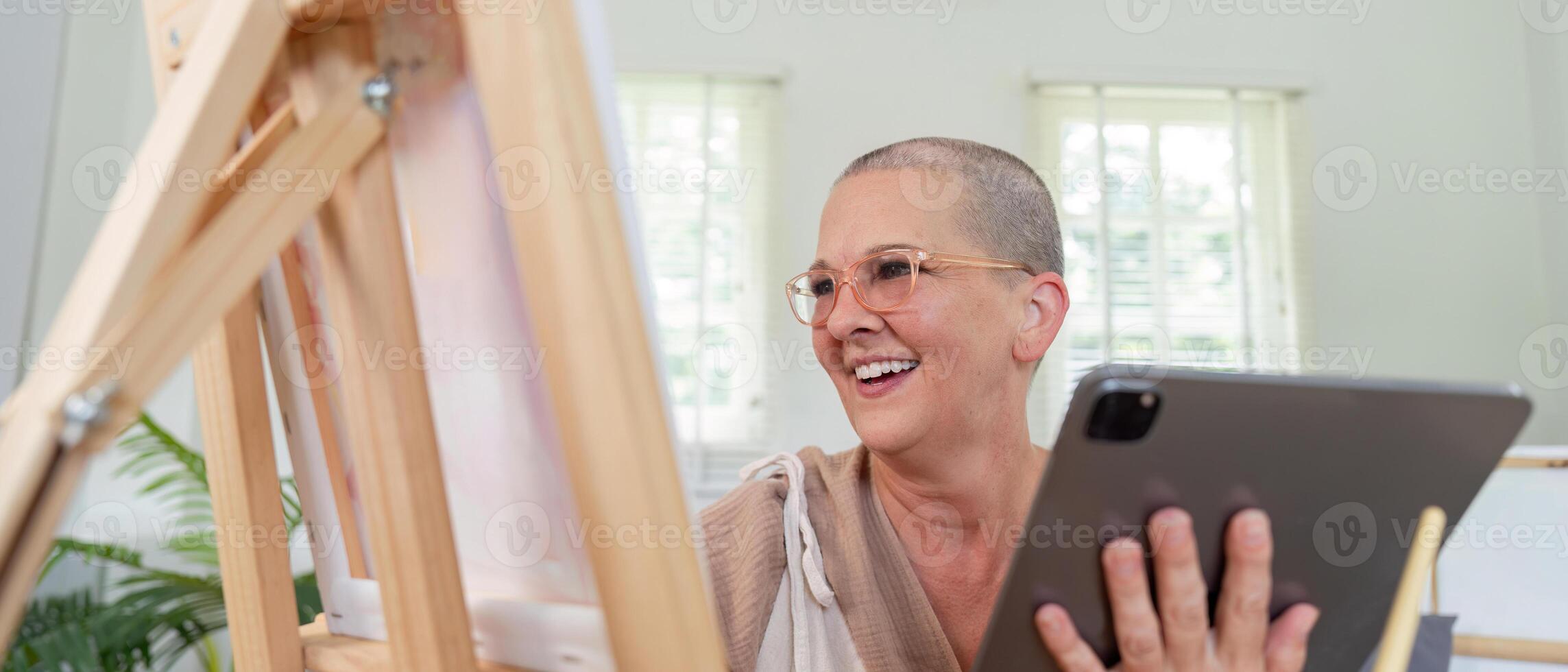 Mature Artist Joyfully Using Digital Tools to Inspire Canvas Work photo