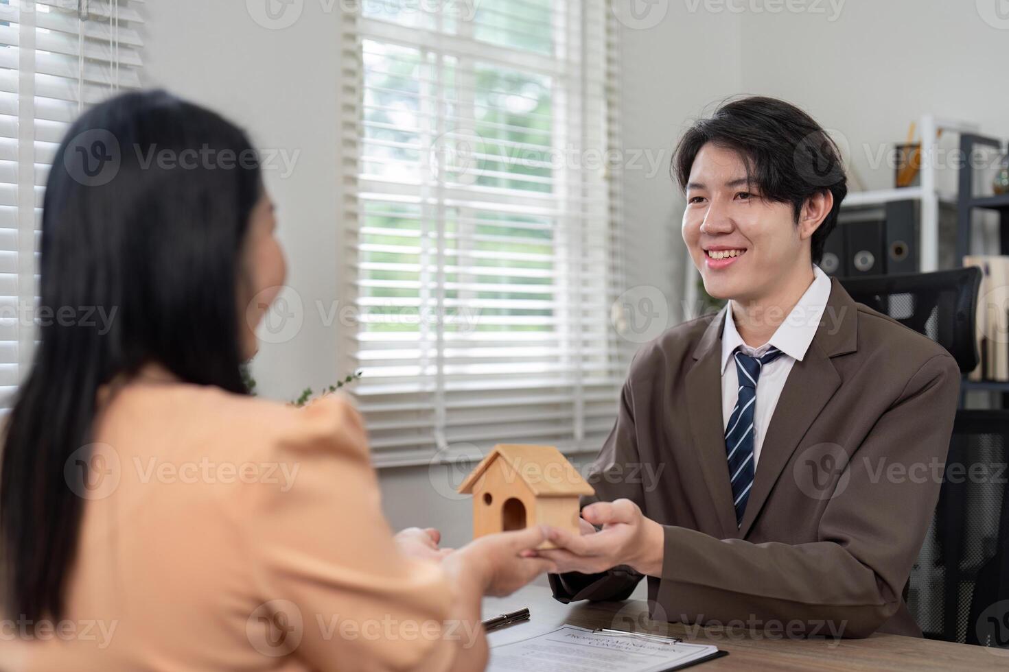 Excited Homebuyer Receiving Property Model from Real Estate Agent photo