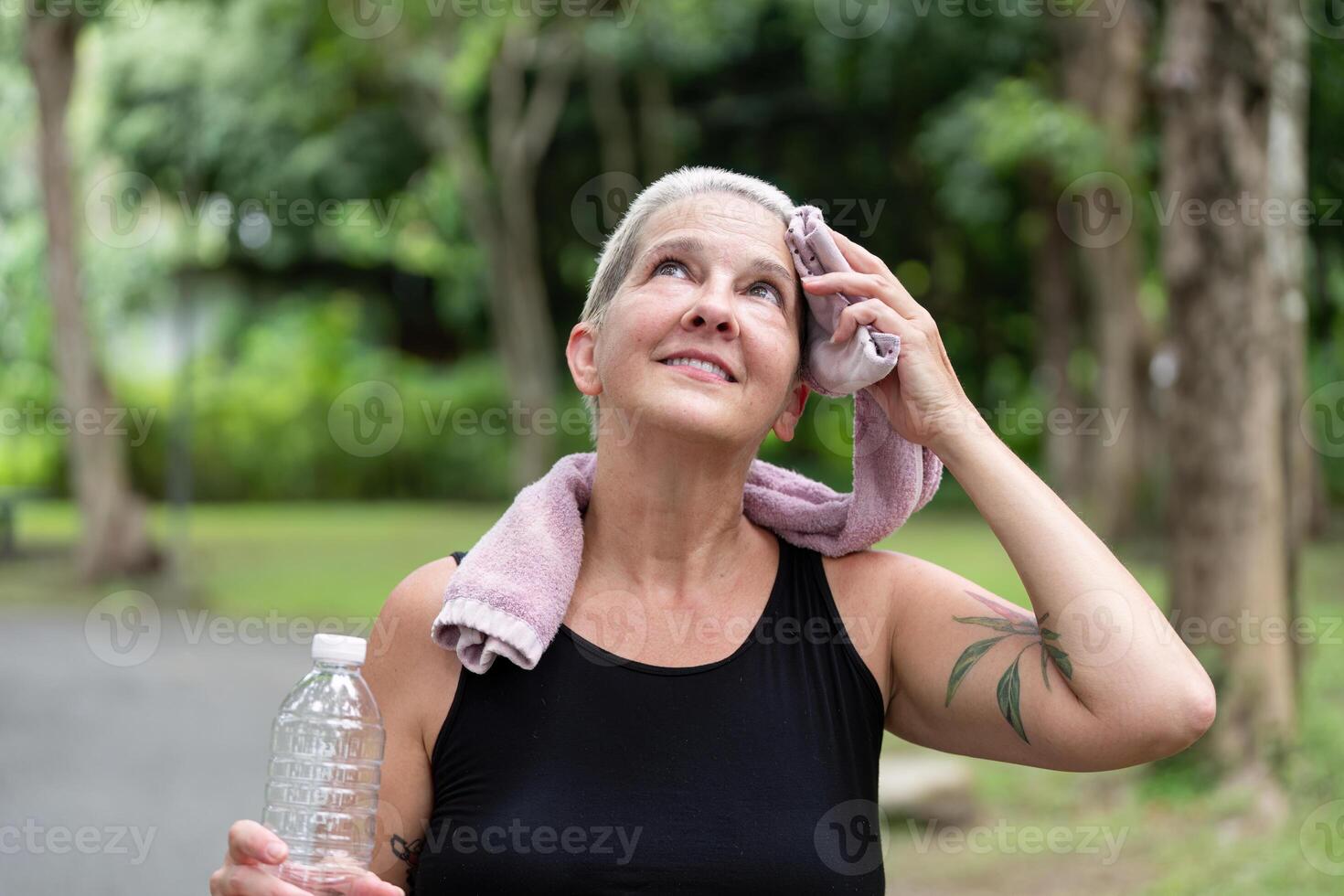 Senior Woman Practicing Wellness Through Outdoor Exercise with Hydration in Focus photo