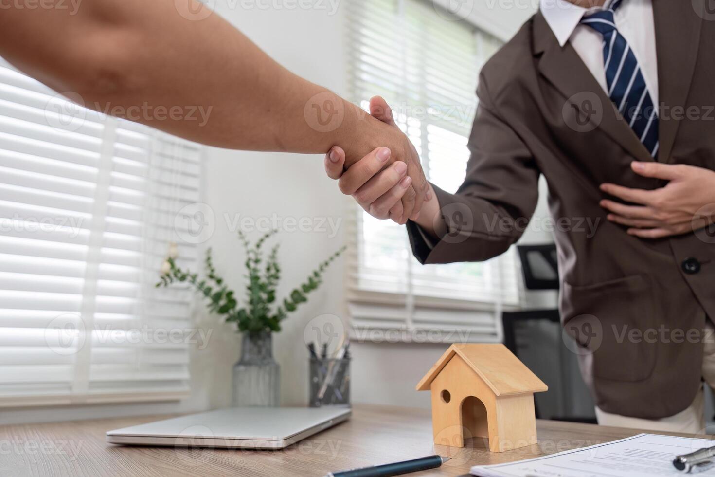 Real Estate Agent Sealing Client Deal with Handshake, Emphasizing Professionalism and Trust photo