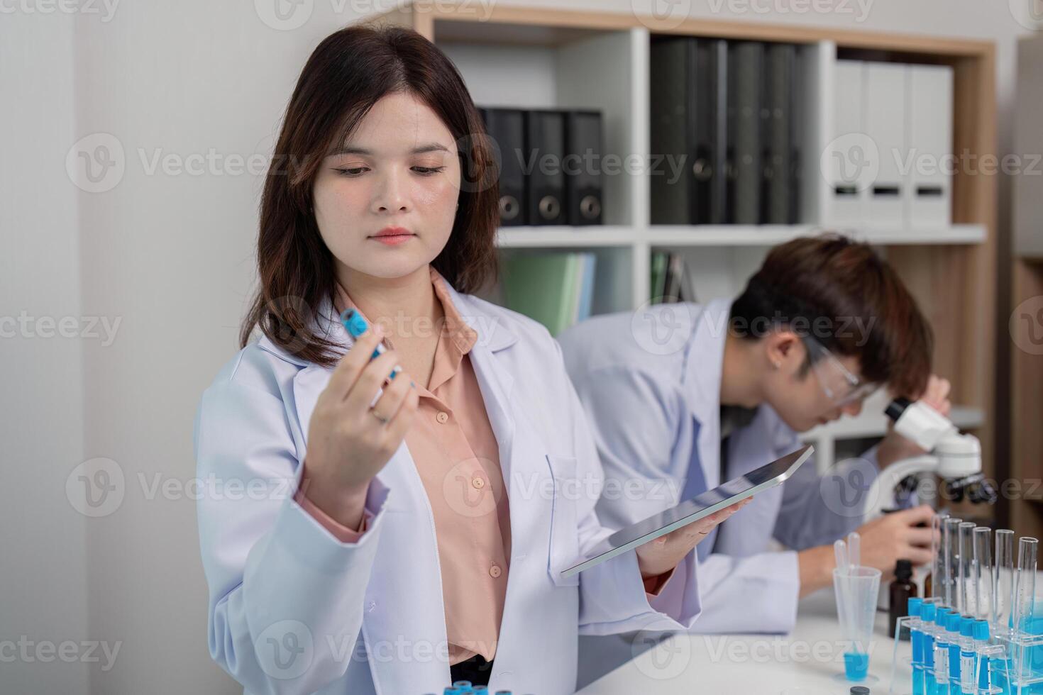 Female Scientist Conducting Chemical Analysis with Specimen and Digital Records photo