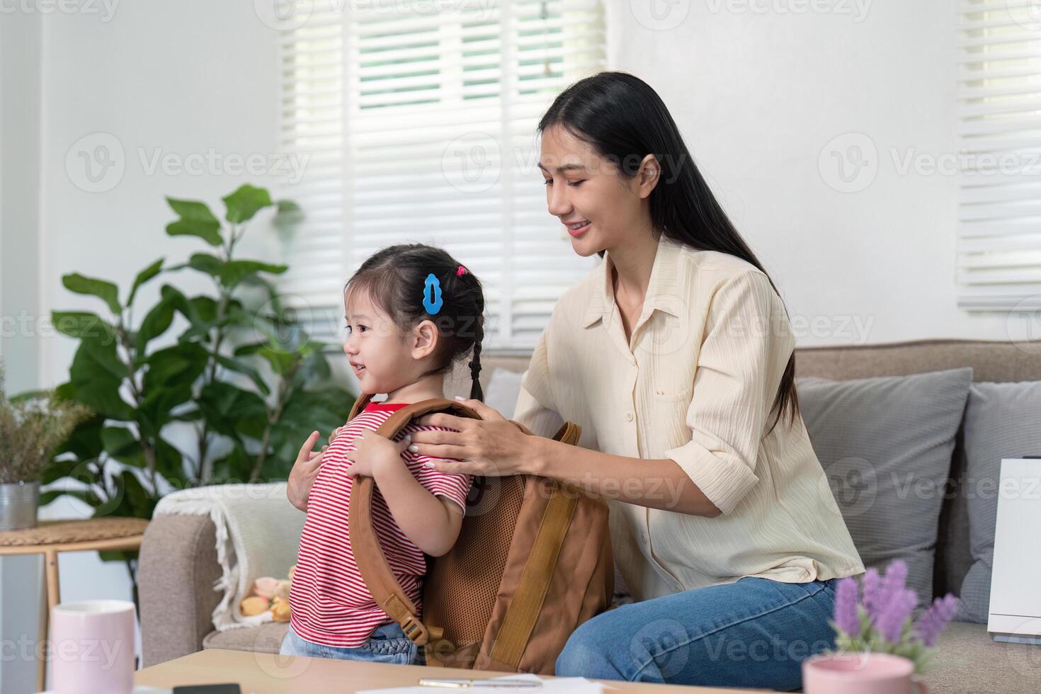 Mother Helping Daughter Prepare for School with Organized Backpack photo