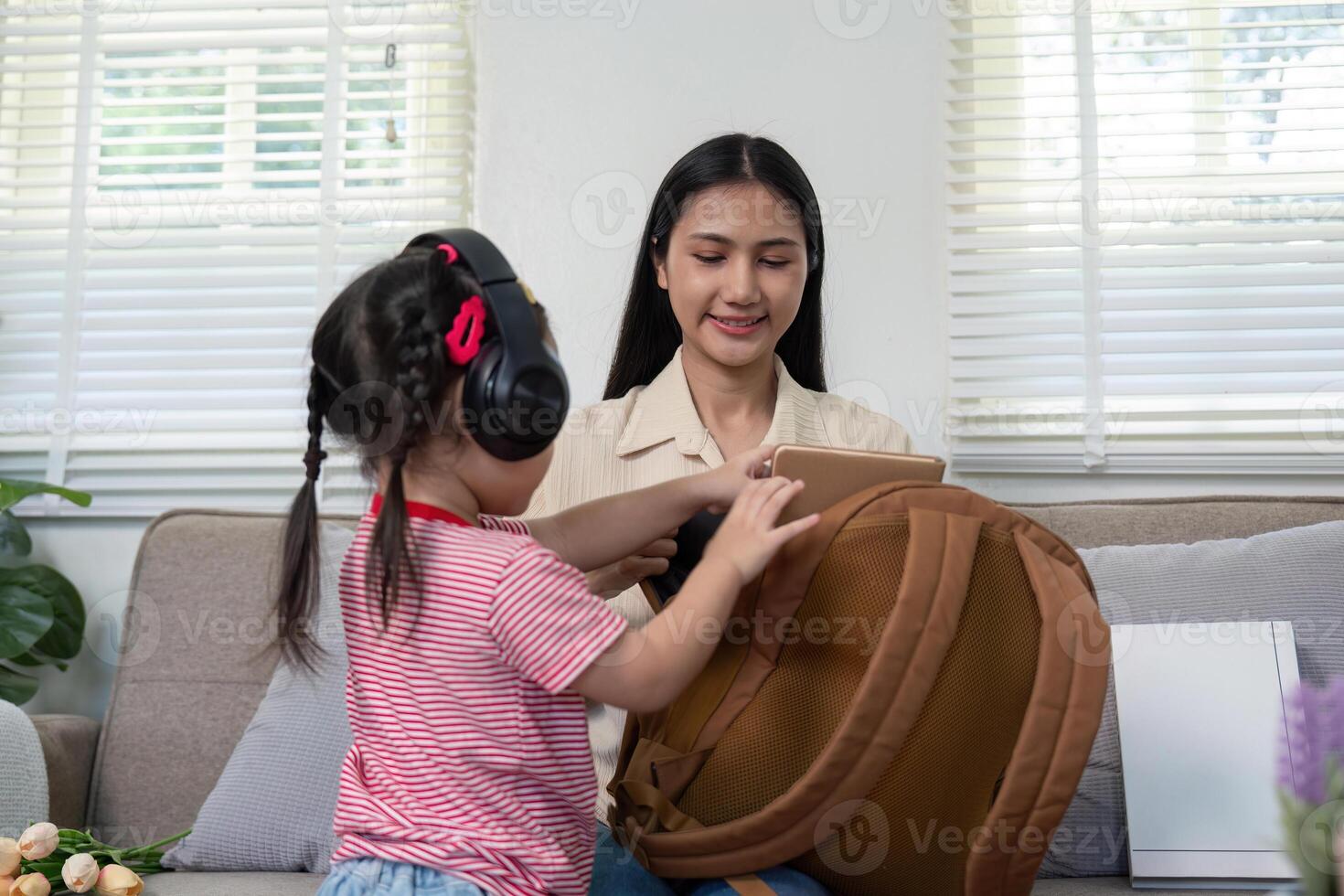 Mother Preparing Child for School with Backpack Organization photo