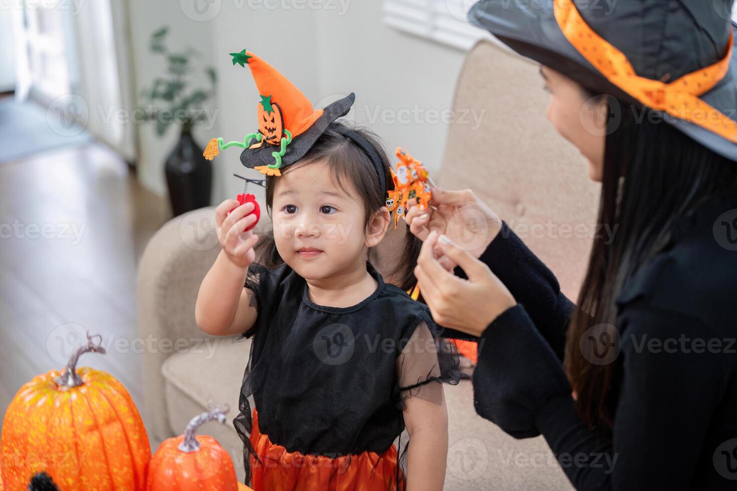 Adorable Child and Mother Engaged in Halloween Crafts with Pumpkins at Home photo
