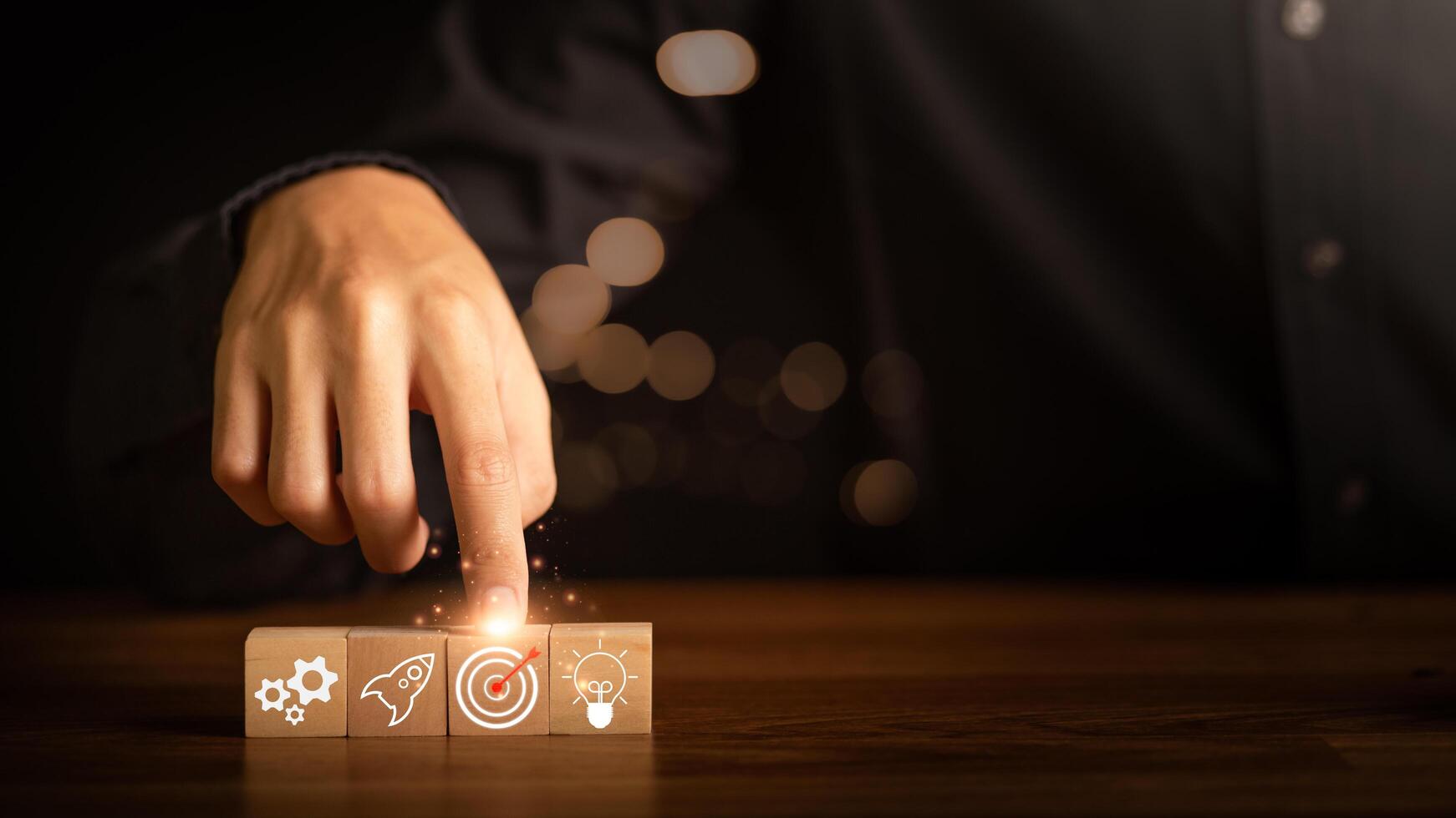 Wooden block in businessman hand and arrow icon hitting center of dartboard target,Setting business goals and focused concepts, Organizational growth and objectives, marketing strategy planning photo