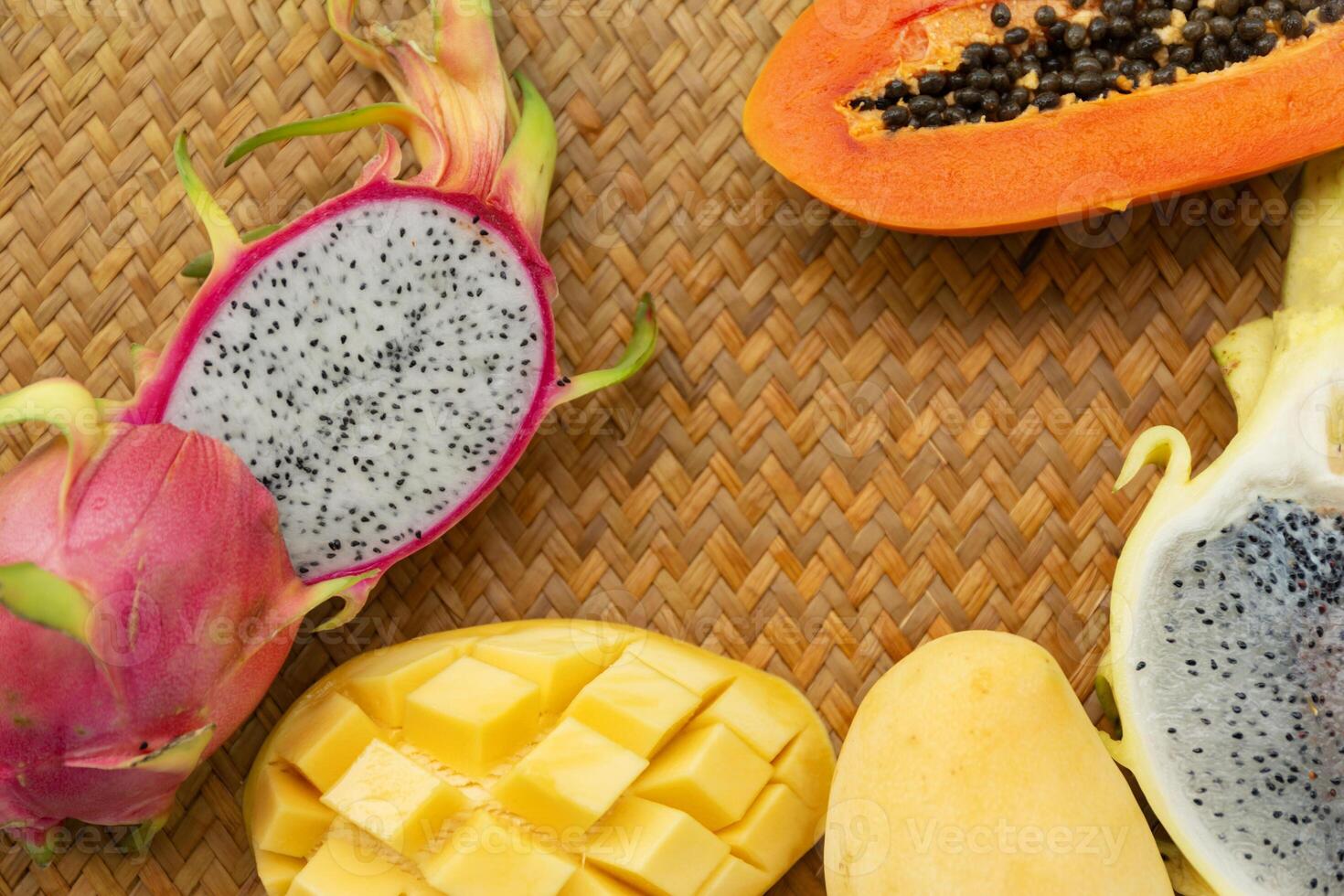 Delicious Exotic Tropic Fruits Top View on Wicker Mat Background photo
