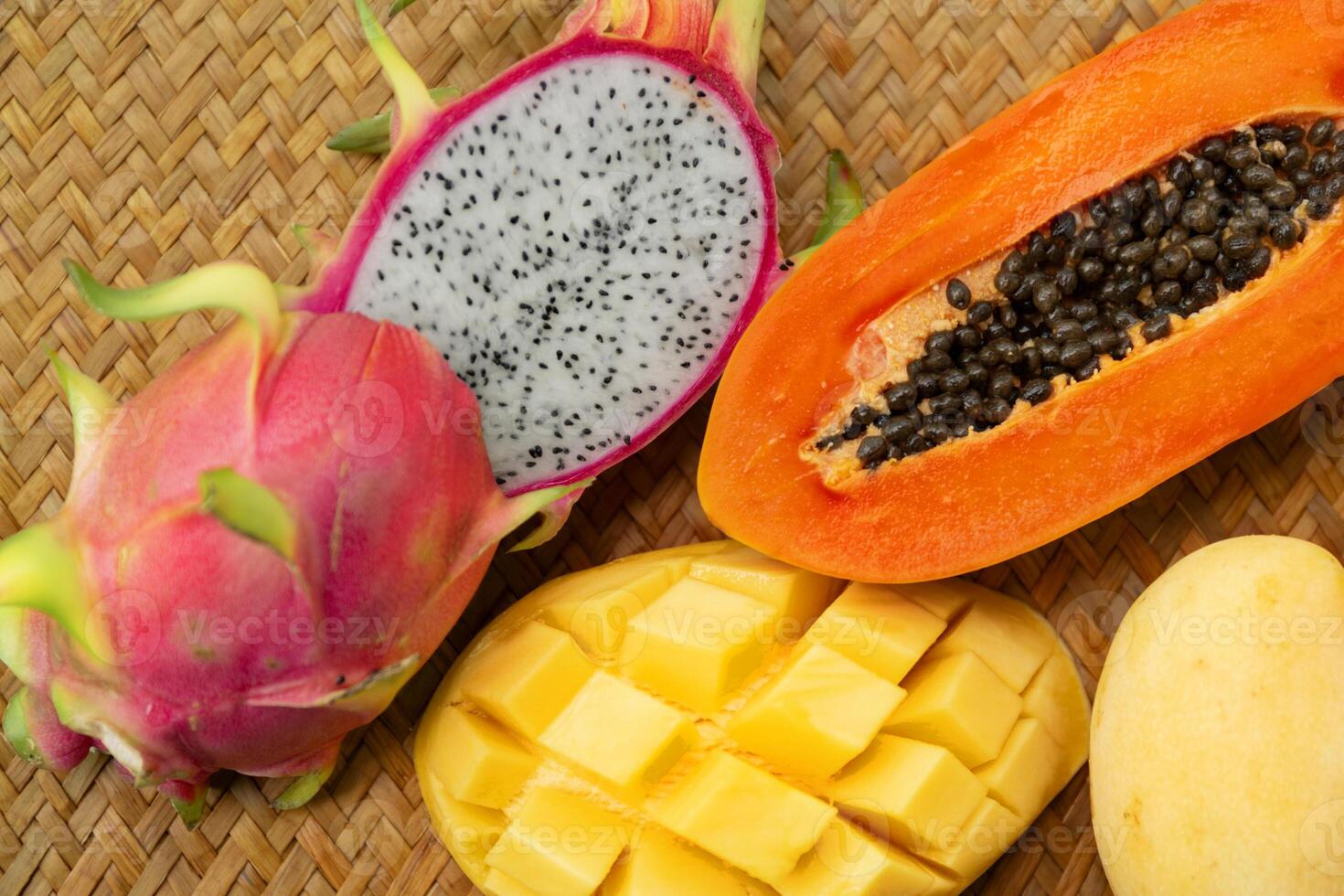 Delicious Exotic Tropic Fruits Top View on Wicker Mat Background photo