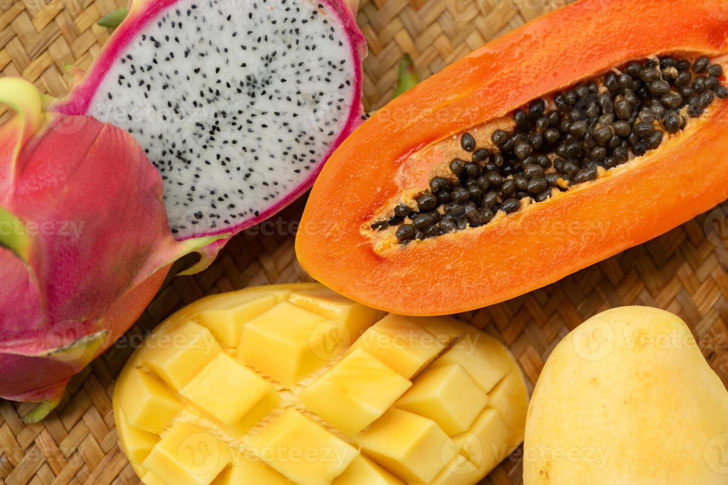 Delicious Exotic Tropic Fruits Top View on Wicker Mat Background photo