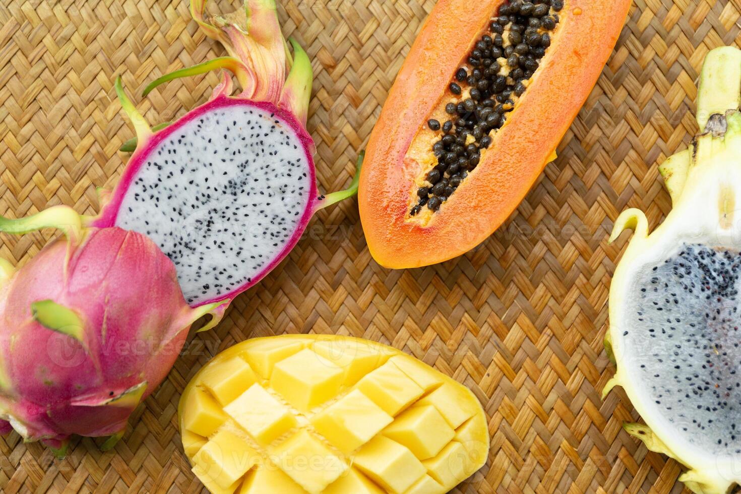 Delicious Exotic Tropic Fruits Top View on Wicker Mat Background photo