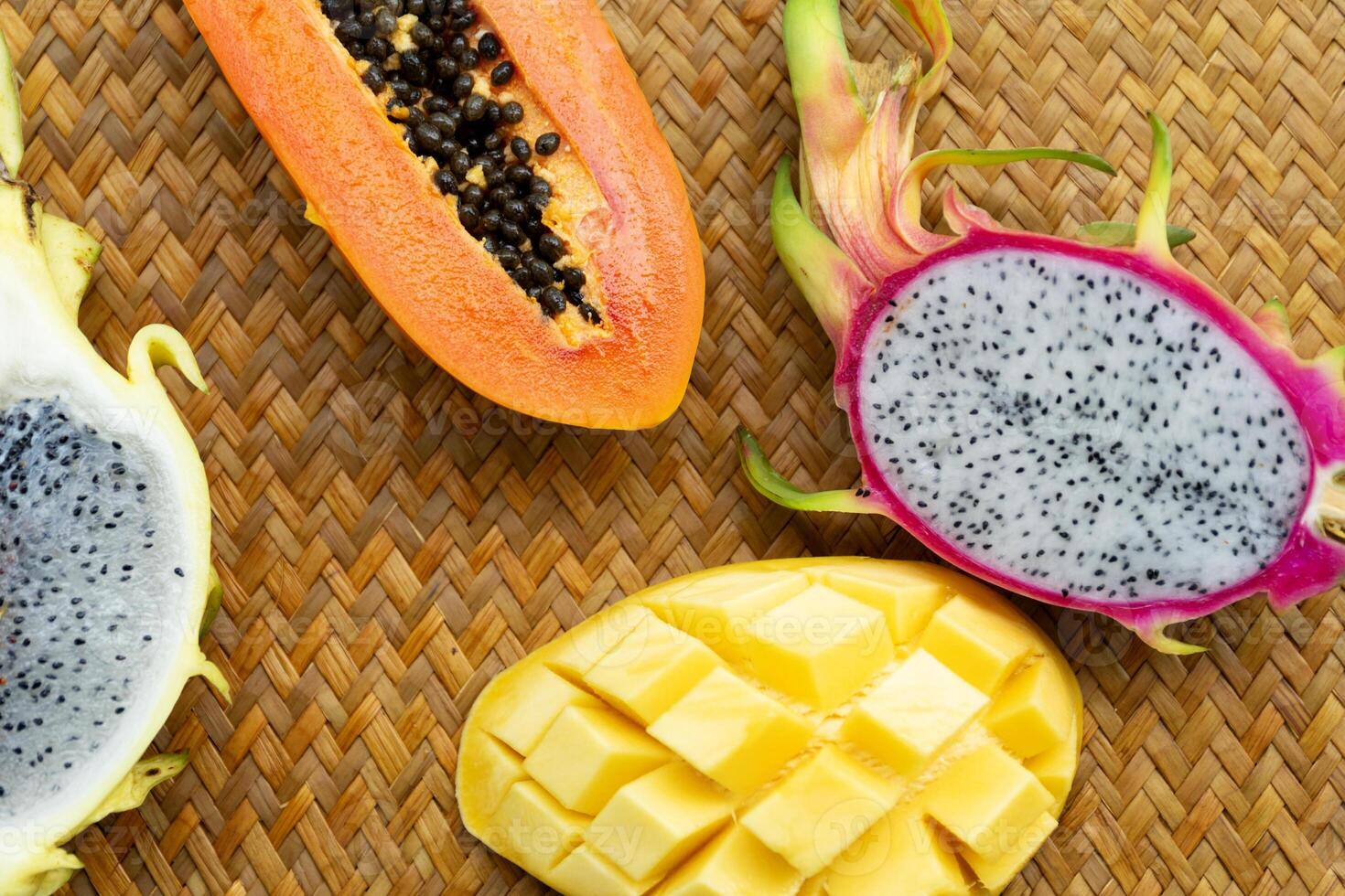 Delicious Exotic Tropic Fruits Top View on Wicker Mat Background photo