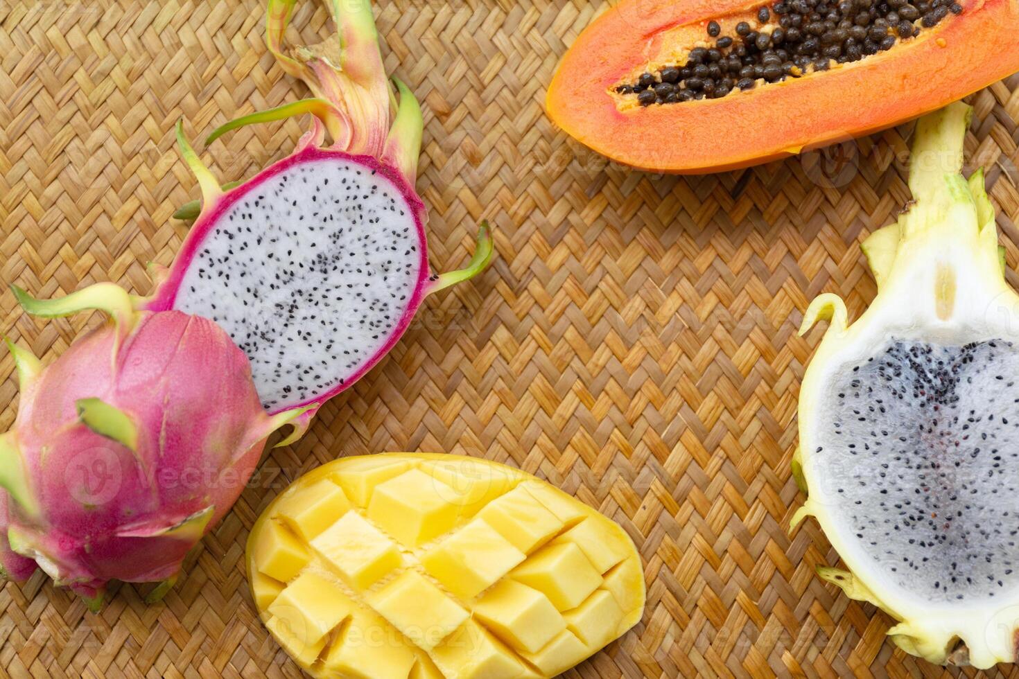 Delicious Exotic Tropic Fruits Top View on Wicker Mat Background photo