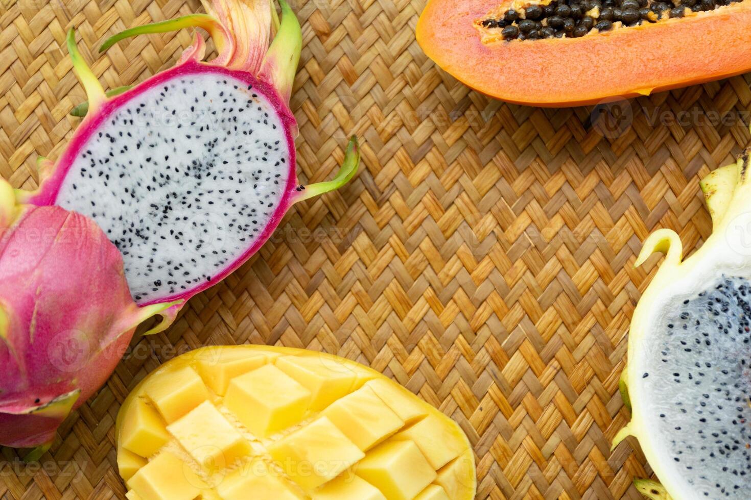 Delicious Exotic Tropic Fruits Top View on Wicker Mat Background photo