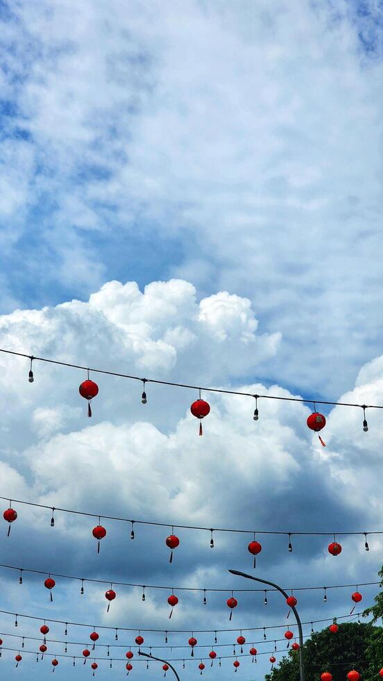 a street with many red lanterns hanging from the wires photo