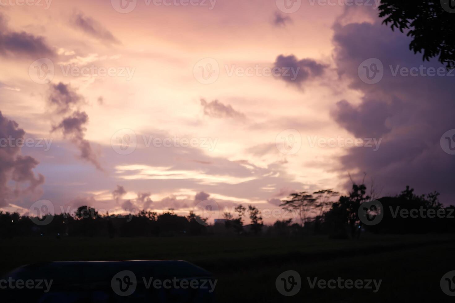 a cloudy sky with a sign in the foreground photo