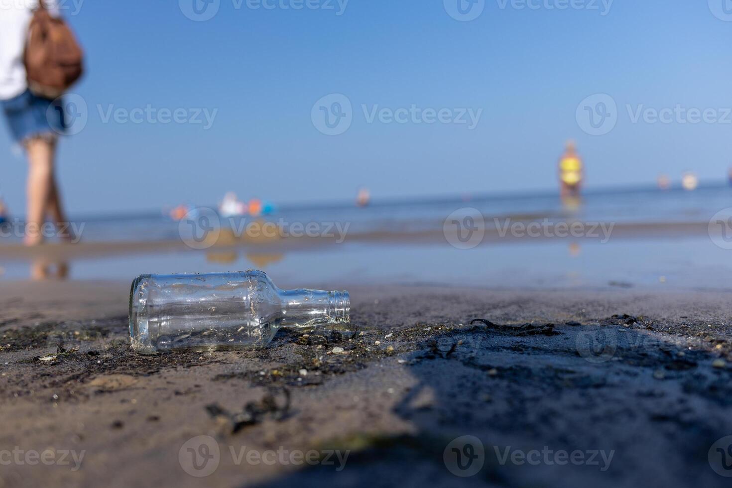 bottle lying on the beach , seashore, dirty coastline photo
