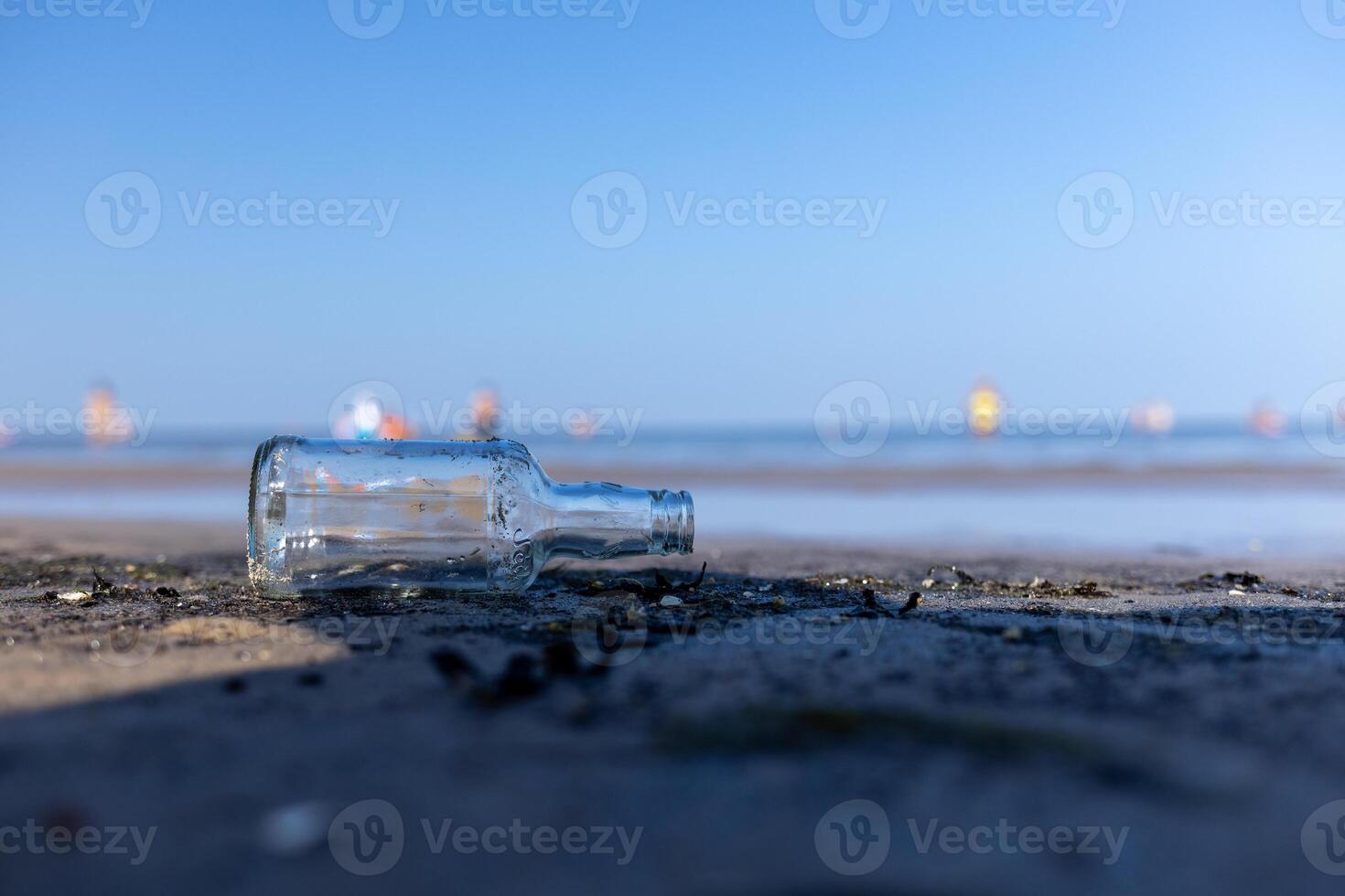 bottle lying on the beach , seashore, dirty coastline photo