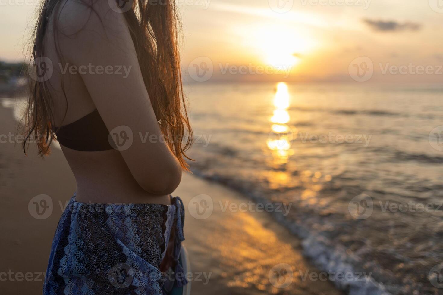 girl enjoys sunset on the sandy beach in Greece photo